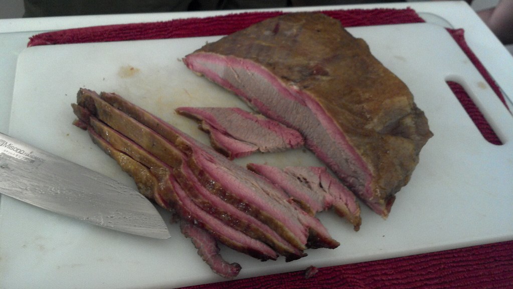 Sliced smoked brisket on a wooden board after a low and slow cook
